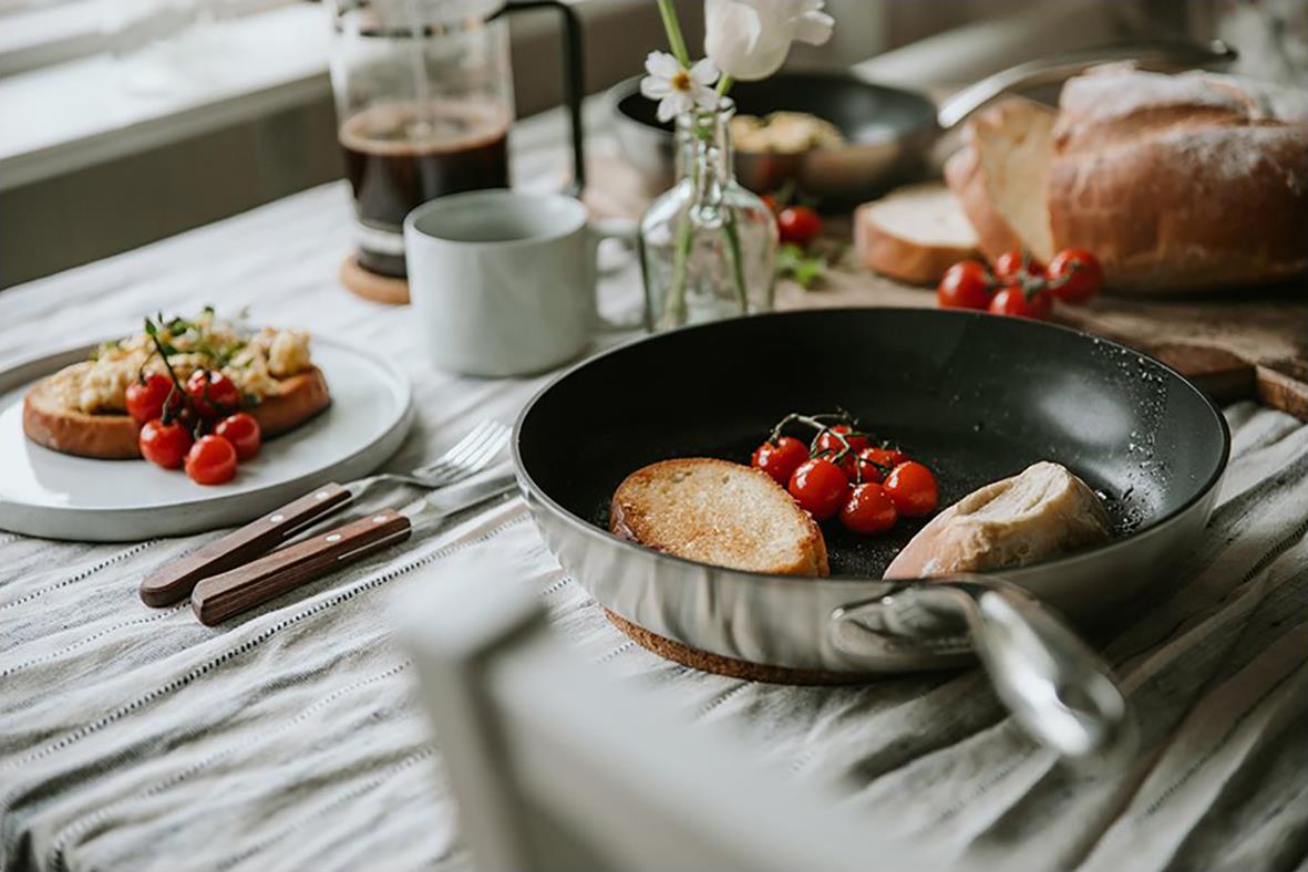 " med tomater och bröd på köksbord, bakgrund med drycker och köksredskap"