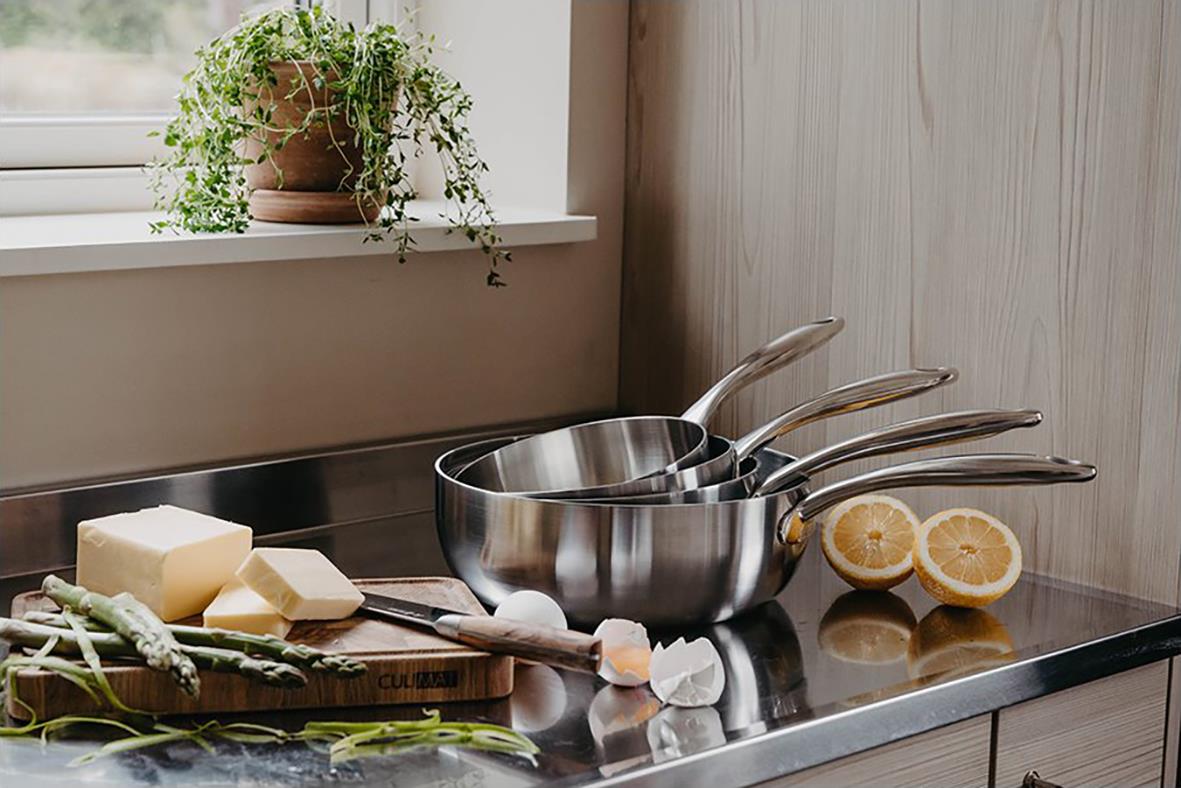 Tre rostfria såskastruller på köksbänk med citron och smör