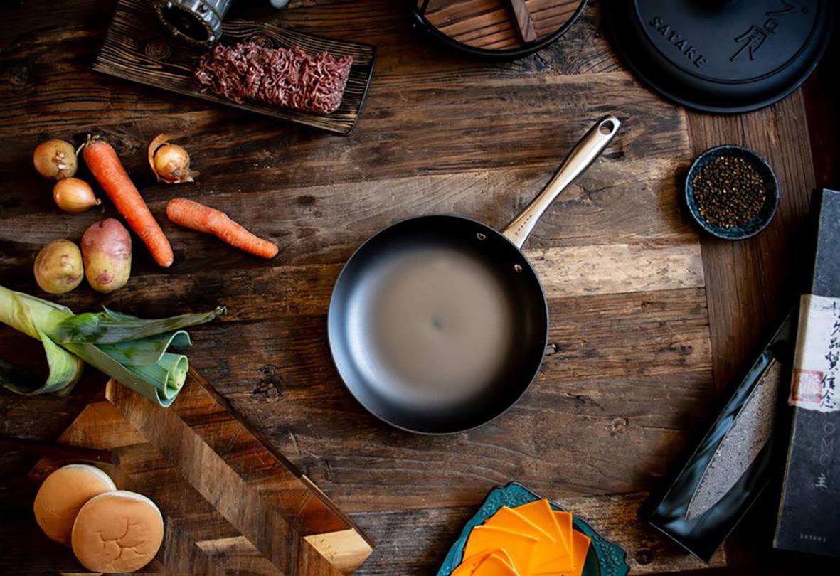 Stekpanna Satake Nitriding Ø24cm på träbänk med ägg, grönsaker och kryddor runtom