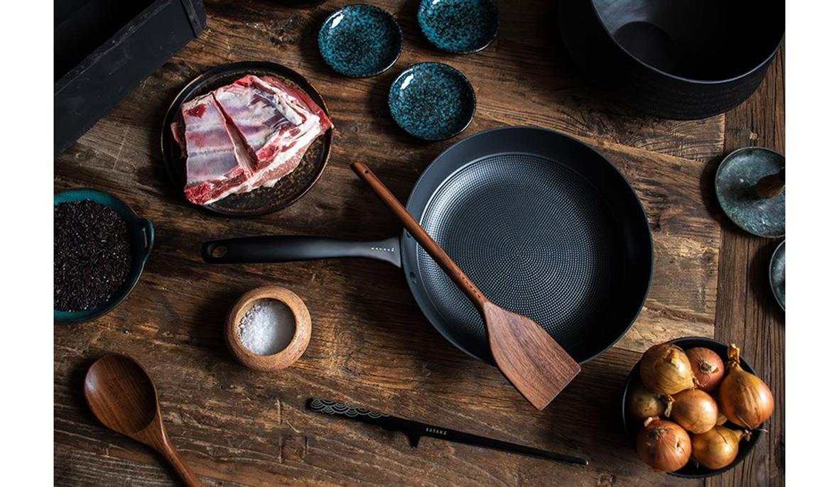 Stekpanna Satake Lättviktsgjutjärn Ø28cm på ett träbord med olika köksredskap och ingredienser