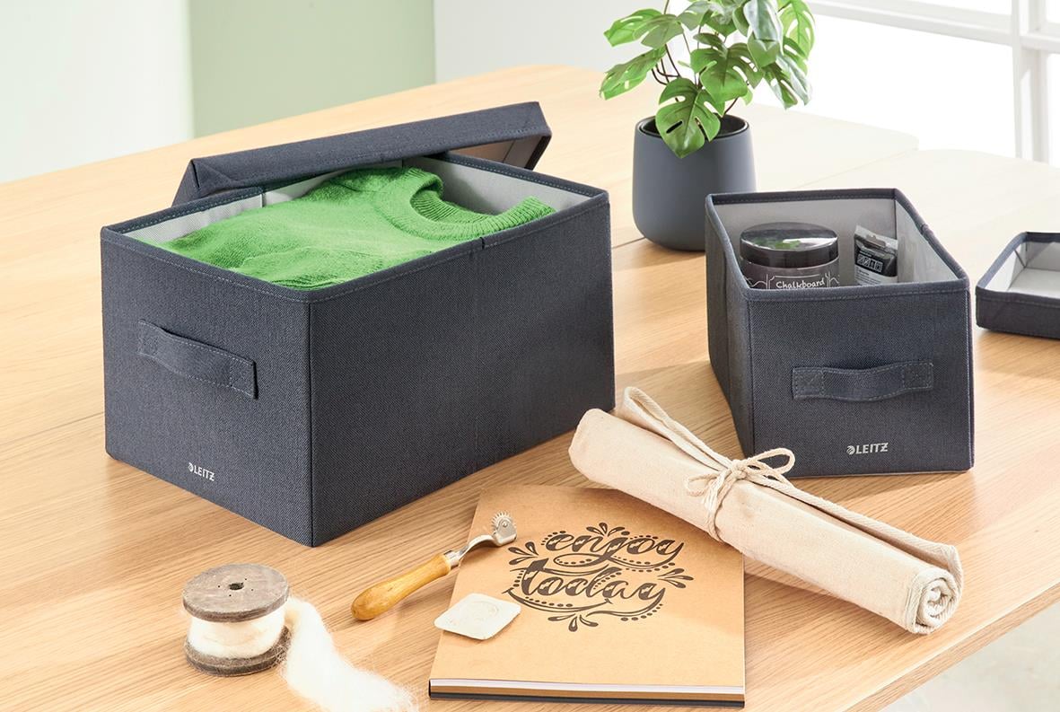 Förvaringslåda Leitz Tygklädd med lock i grått på ett bord med andra förvaringsartiklar