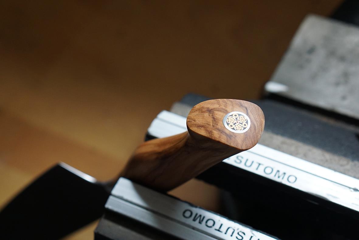 Kockkniv Ryda Knives 21cm med trähandtag liggande på böcker