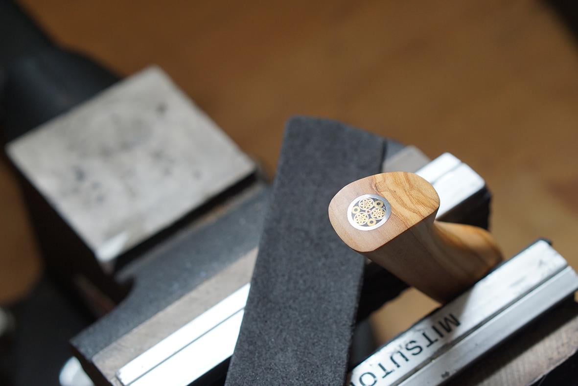 Allkniv Ryda Knives 13cm med trähandtag och svart blad, placerad på arbetsbänk