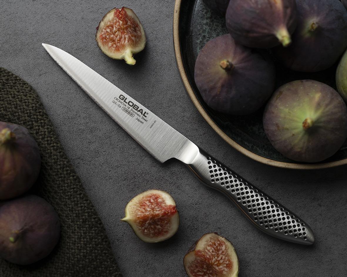 Allkniv Global GS-36 11cm med perforerad handtag, omgiven av fikon och en skål