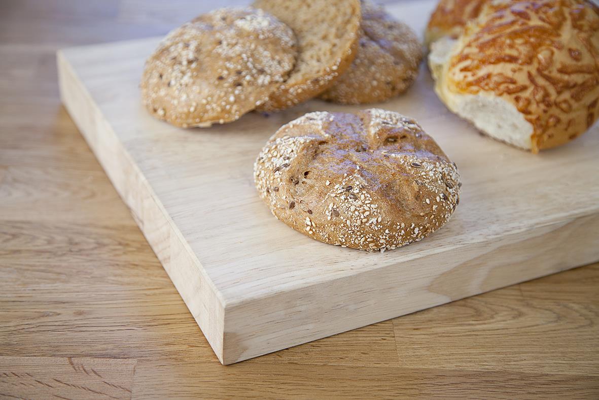 Bröd på en träbricka, inklusive knäckebröd och ett annat bröd