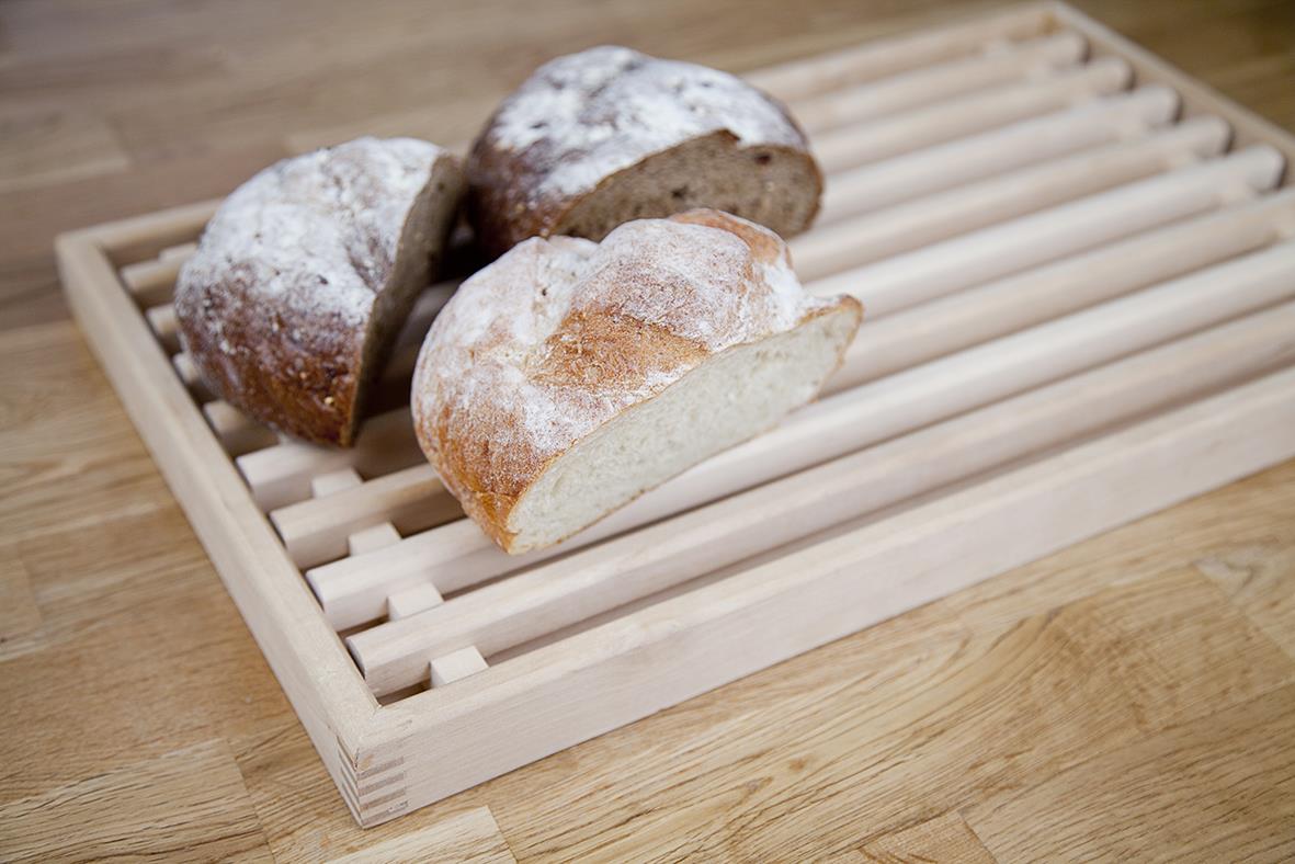 Björkbrödskärbräda 50x30cm med tre bröd på, på en träbänk