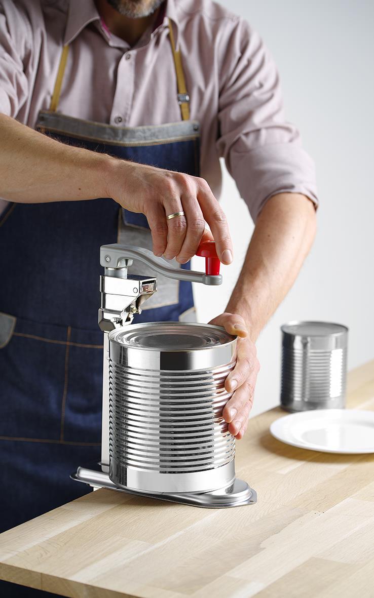 Person använder en Hendi konservöppnare för att öppna en stor konservburk på ett köksbord