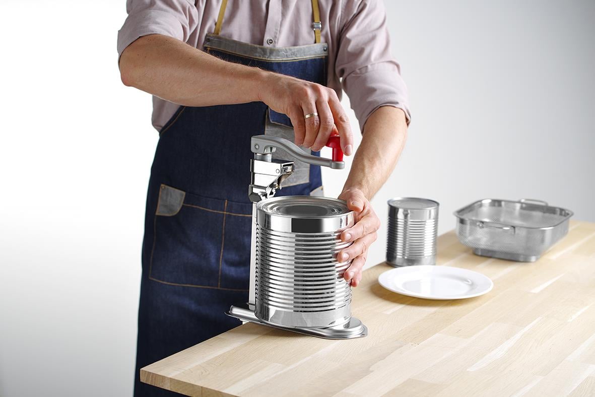 Person använder en Hendi konservöppnare för att öppna en burk på ett köksbord