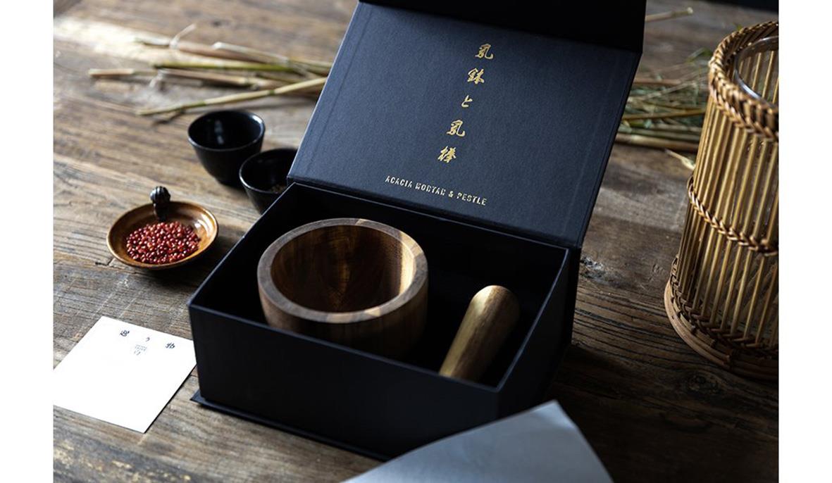 " med mortel av svart akacia, diameter 125 mm, höjd 90 mm, omgiven av te- och kryddkärl på träbord."