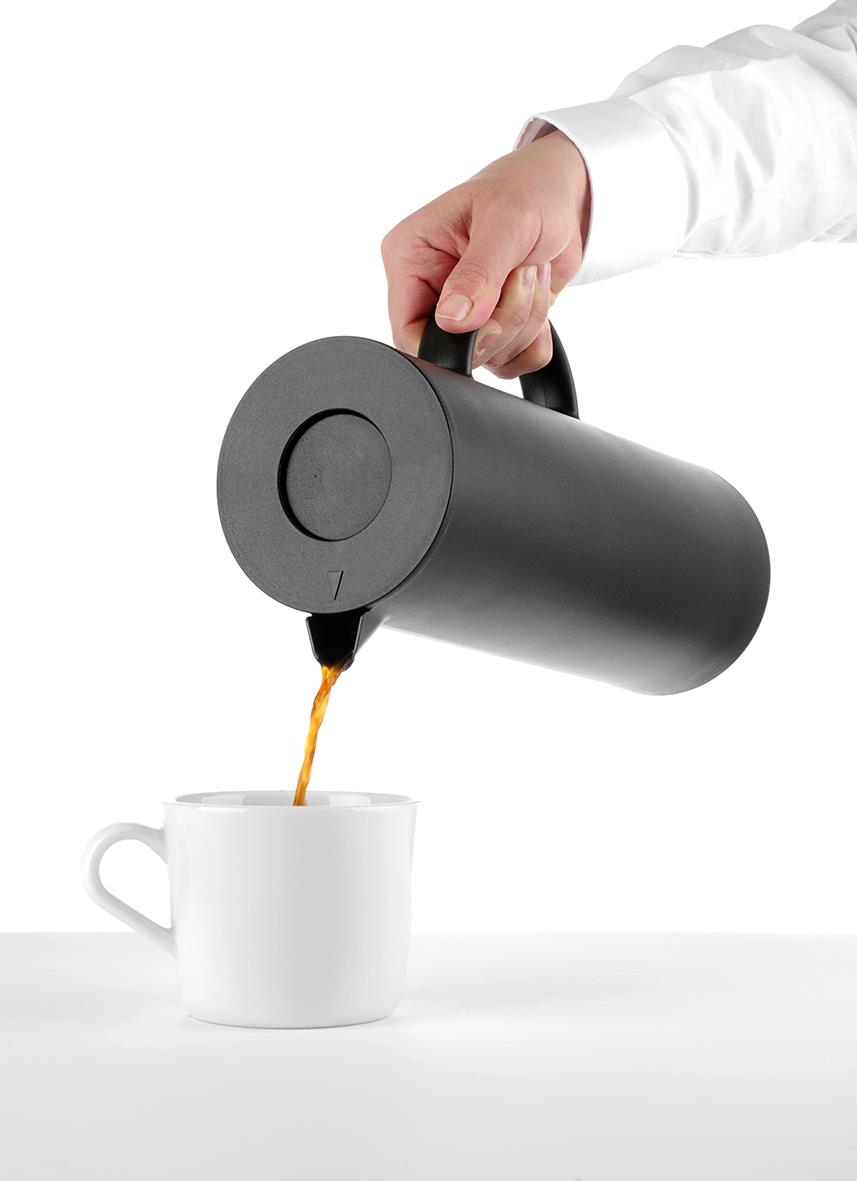 Svart termoskanna Hendi som hälls varm dryck i en vit kopp