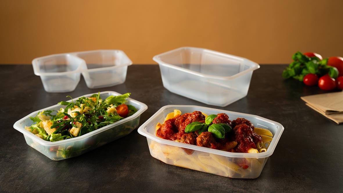 Tre plastbehållare av Duni PP i olika storlekar, en med sallad och en med köttfärssås, på ett bord