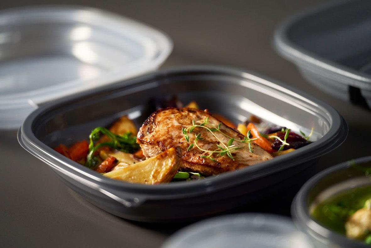 Färdiglagad måltid med kött, grönsaker och pasta i en svart matlåda