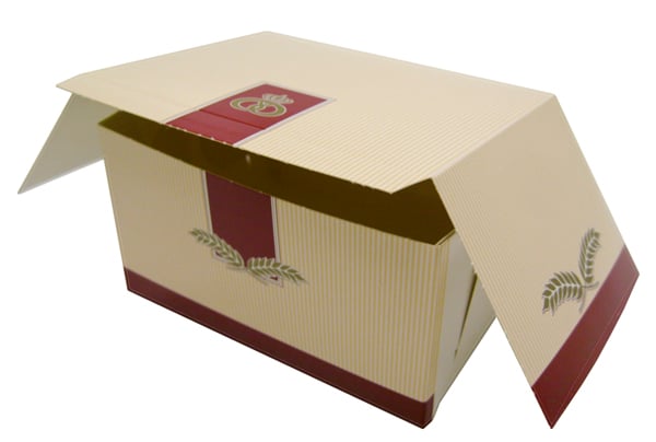 Bakelsekartong i kvadratisk form med öppning upptill, beige med rosa och gröna detaljer, mått 14x11x8cm