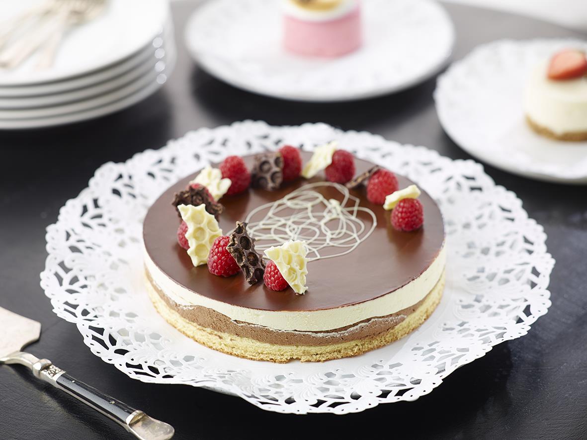 Rund spetspapper på cirka 12 cm med choklad och bär, placerad på ett vitt dekorativt underlägg