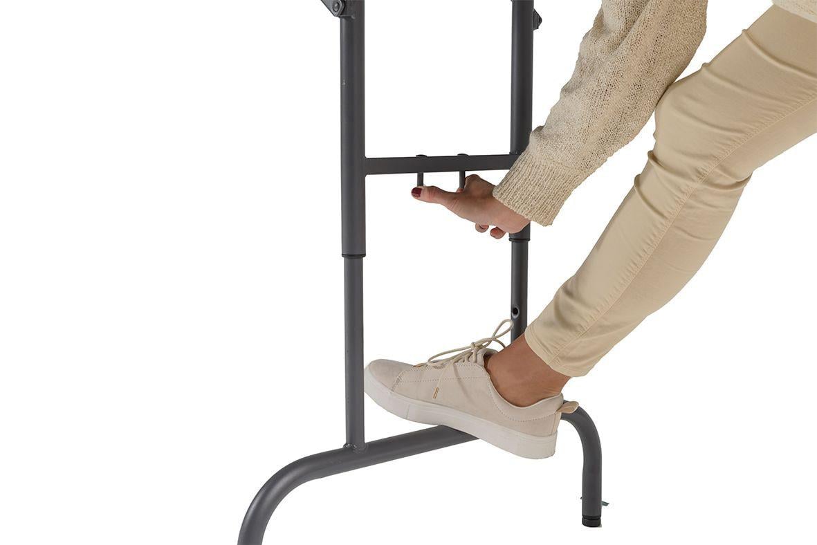 Fällbart bord med mörkgrå yta och svart ram, visar en person som justerar höjden