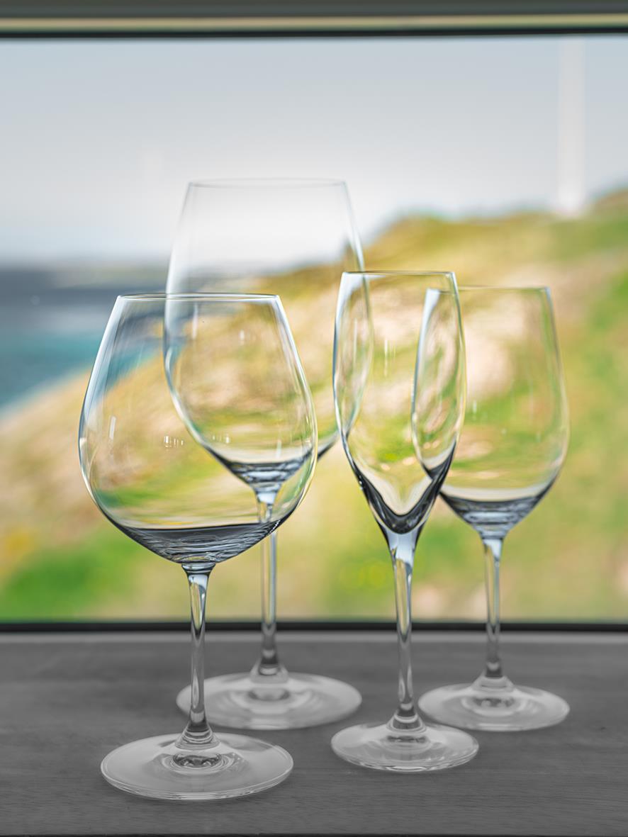 Fyra vinglas av Riedel Vinum Pinot Noir på fönsterbräda med utsikt utomhus