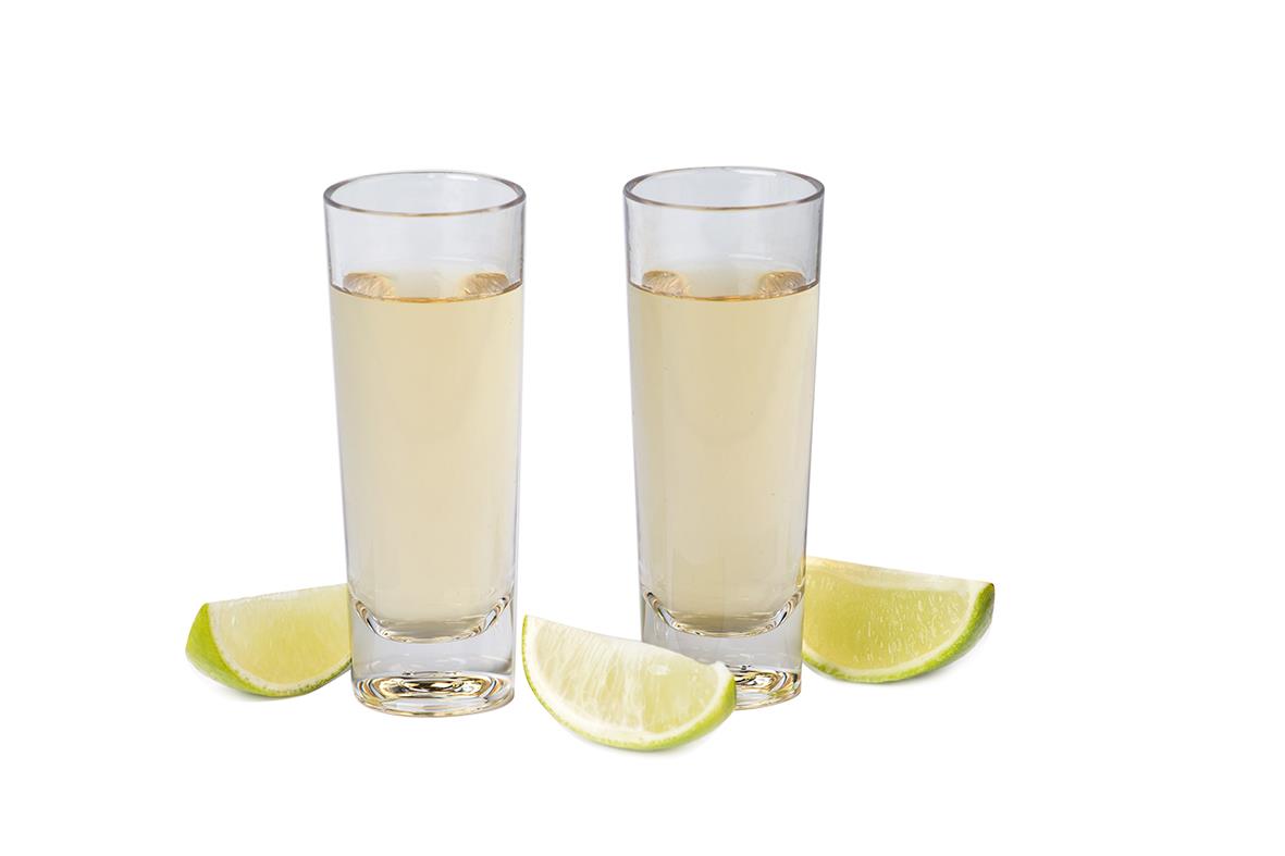 Två shotglas av polykarbonat med citronklyftor framför