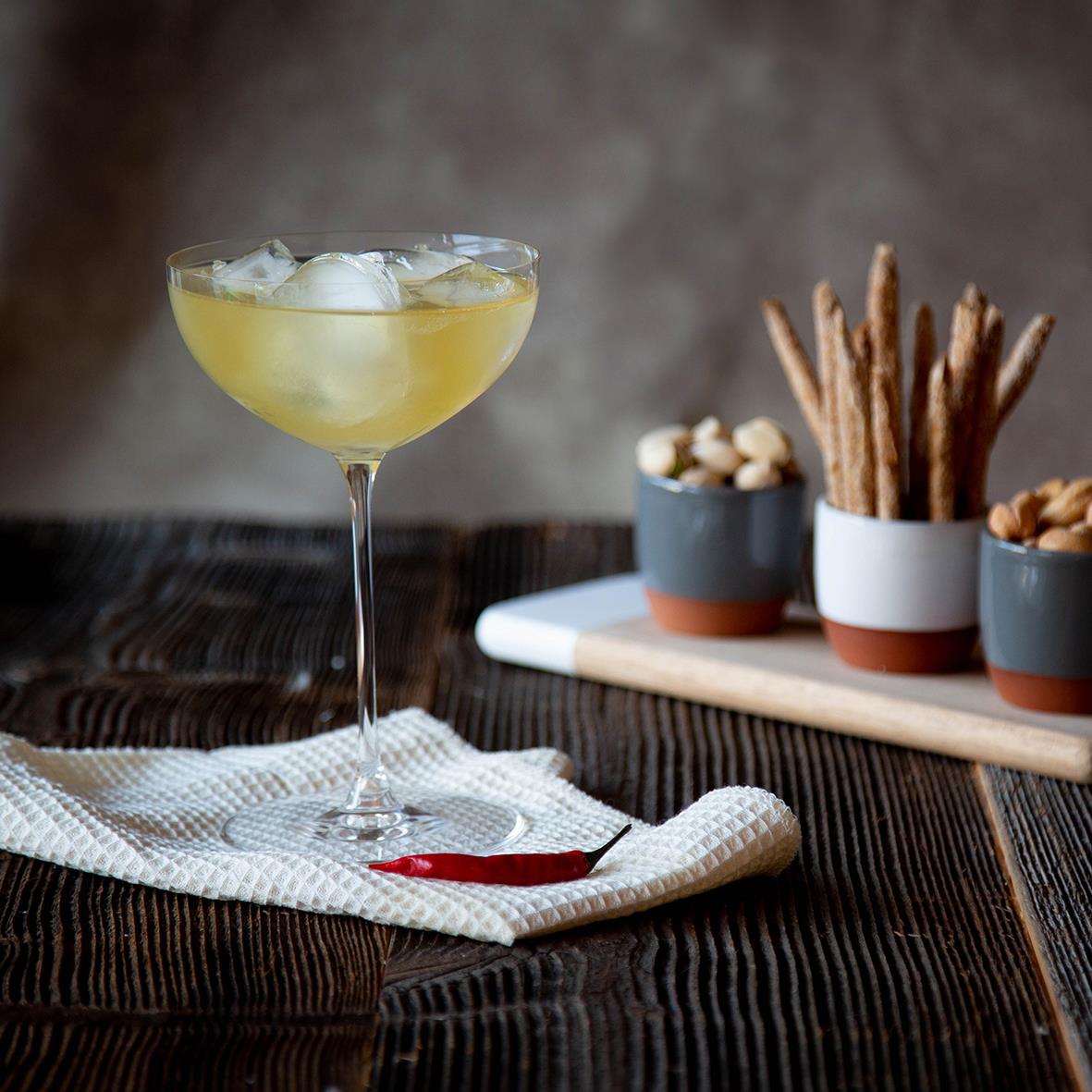 Cocktailglas Riedel Veritas Coupe/Cocktail med drink och tilltugg i bakgrunden