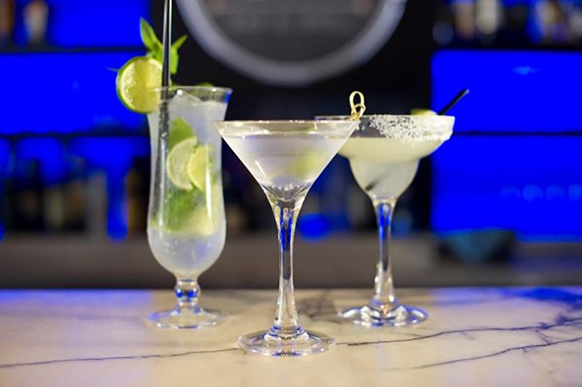 Två cocktailglas och en drink i ett polykarbonat martiniglas på bar