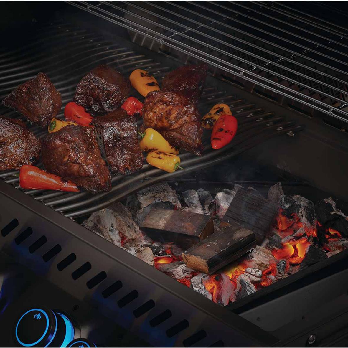 Köttbitar och grönsaker grillas på koltråg Napoleon i en grill