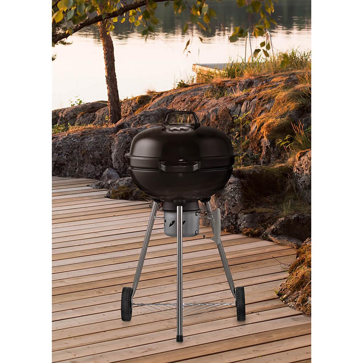 Kolgrill Mustang Basic 47 på trädäck vid vatten med träd och stenar i bakgrunden