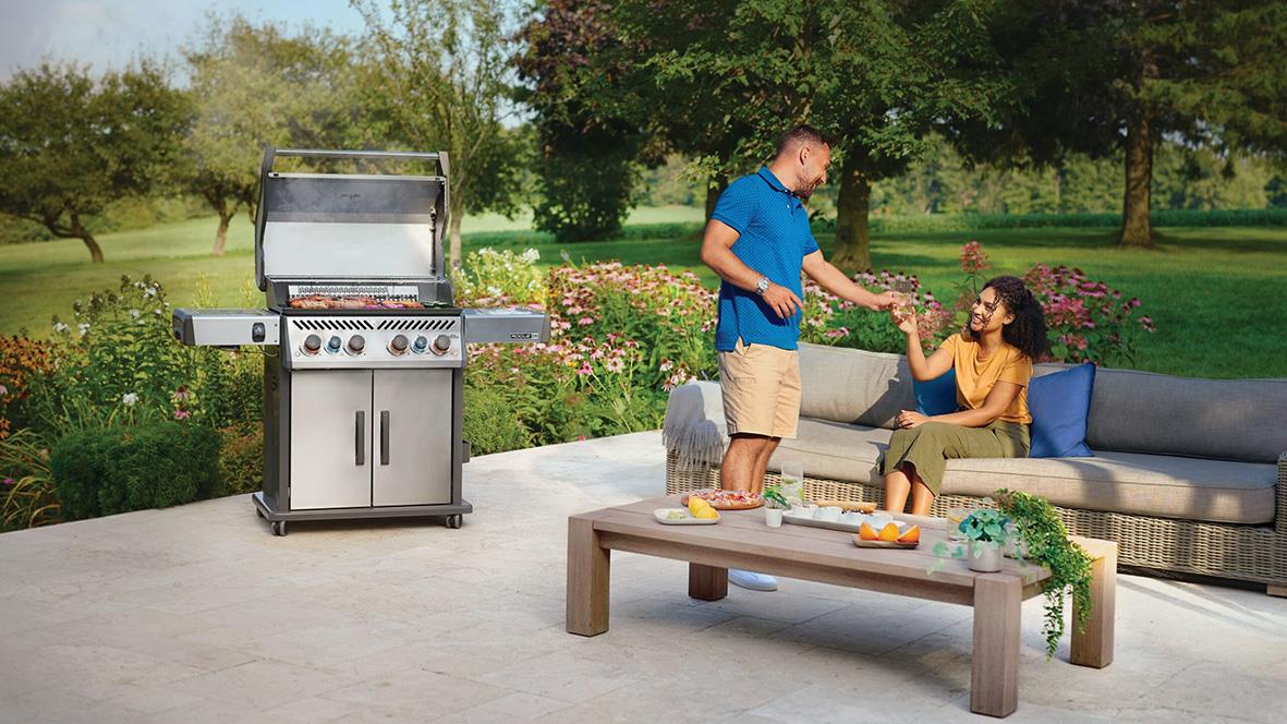 Två personer njuter av en utomhus grillkväll med en stor gasolgrill Napoleon Rogue PRO-S 525 på en uteplats