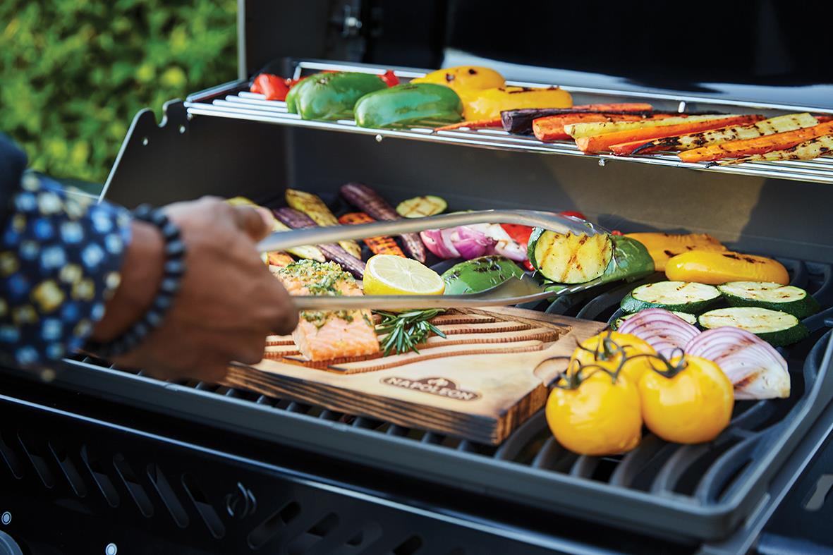 Gasolgrill Napoleon Rouge 425-2 med tre brännare, fylld med grönsaker och mat, svart