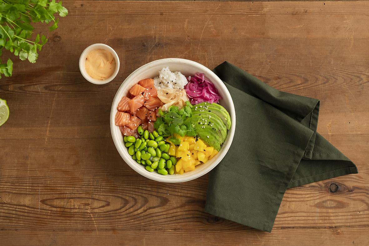 Sallad i brun Duni Bagasse salladsskål på träbord med svart servett och liten sås