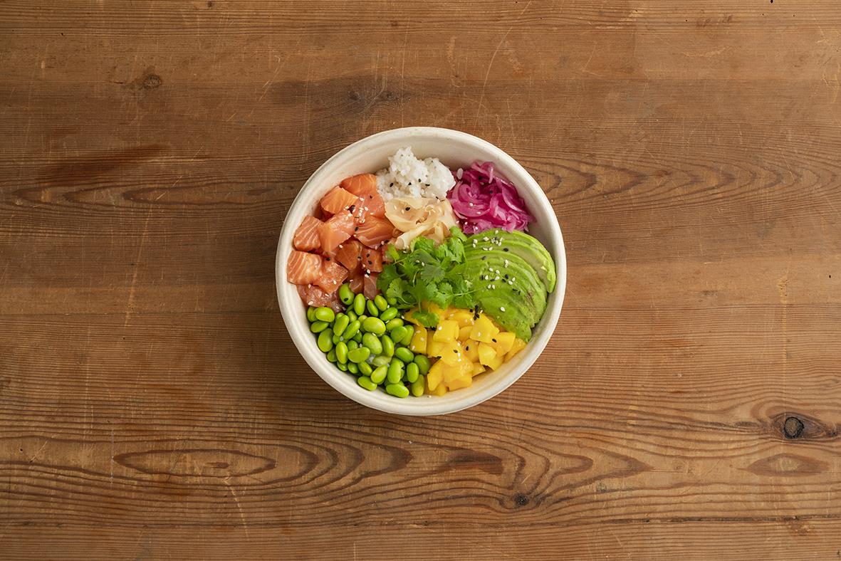 Vit salladsskål med sallad och grönsaker på träbord