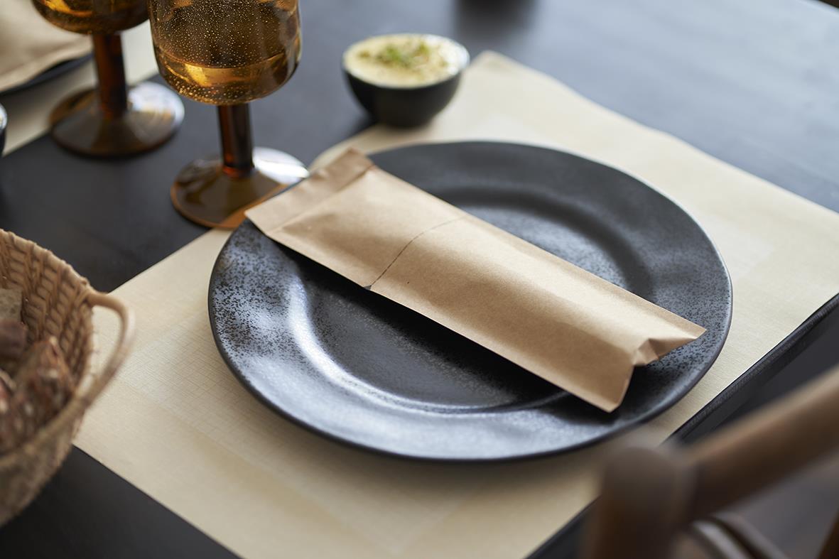 Servettficka Duni Sacchetto förslutbar i brunt papper på svart tallrik