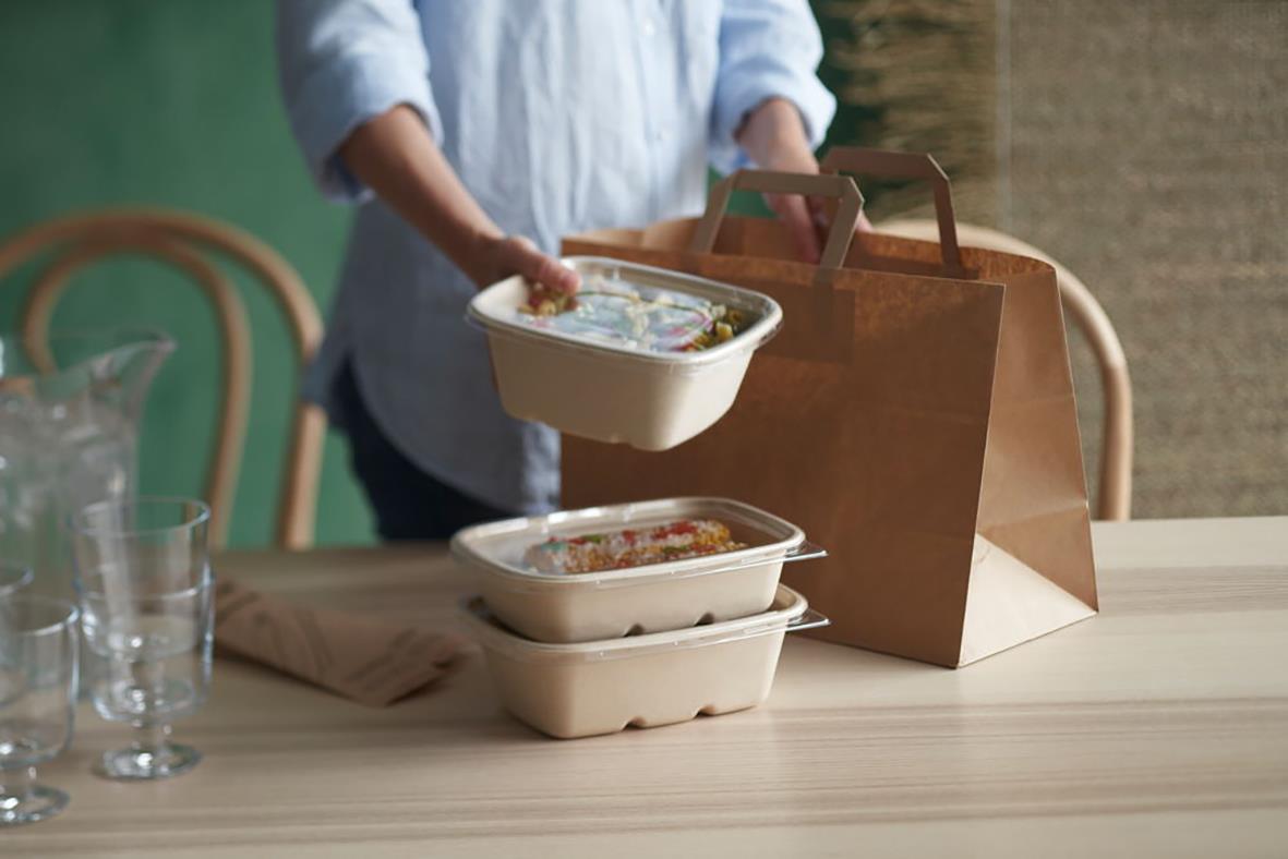 Person som packar Duni Cube rPET lock till pappersform i olika storlekar på ett bord