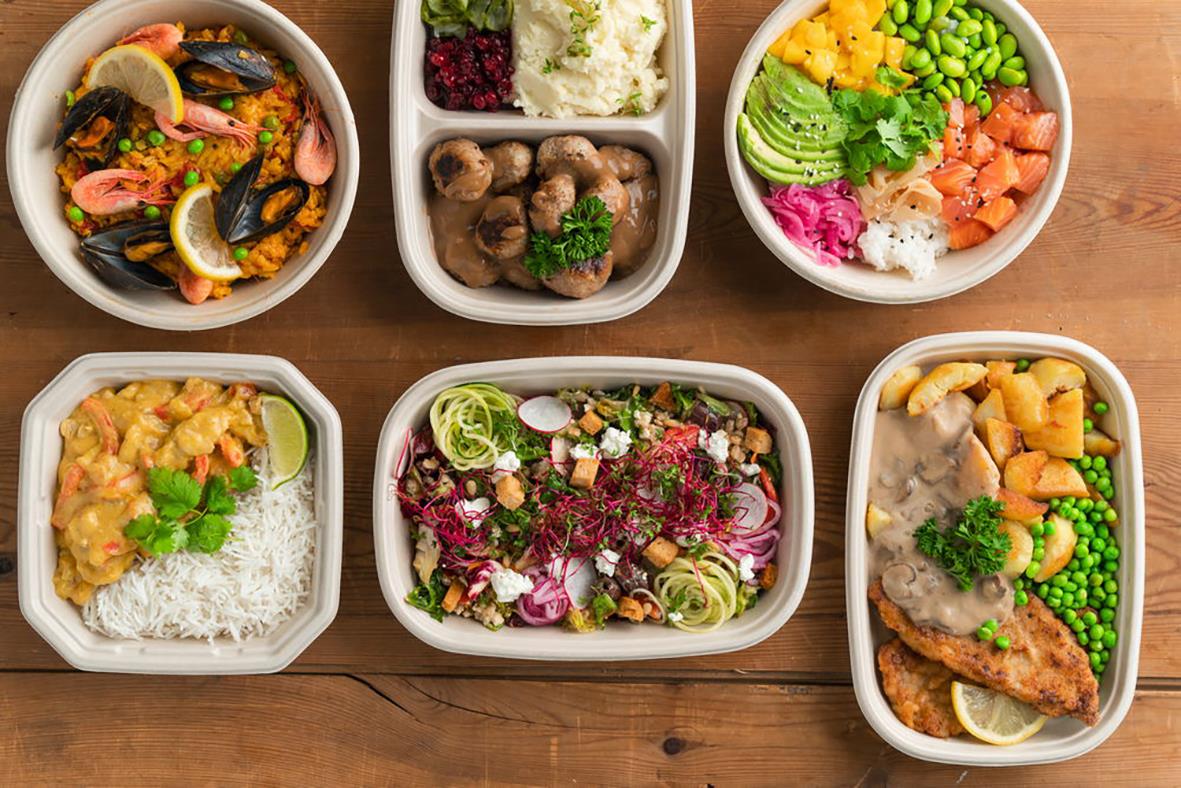 Flera matlådor med olika maträtter på ett träbord, alla i pappersform Duni Cube Bagasse Brun 249x172x30mm 800ml