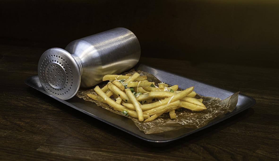 Serveringsbricka i rostfritt stål med mat och dryck på en mörk träyta