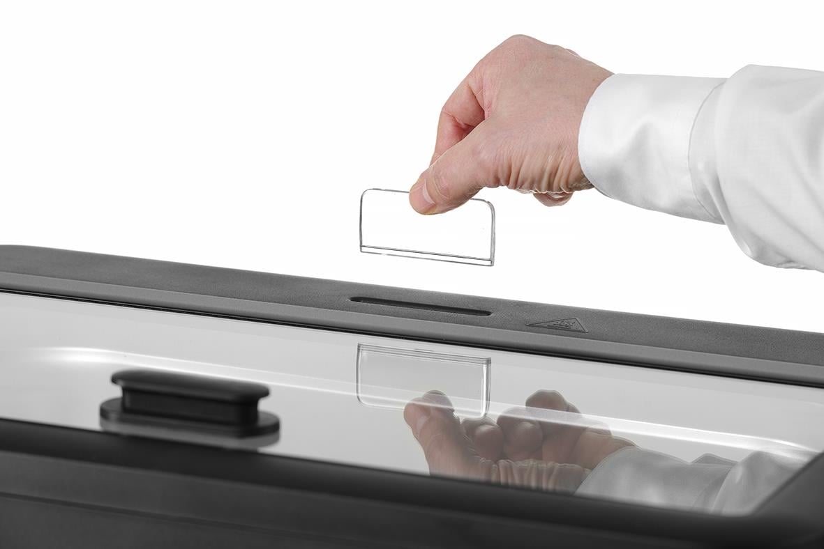 Hand som placerar ett lock på en vit chafing dish från Hendi Hedi Uniq