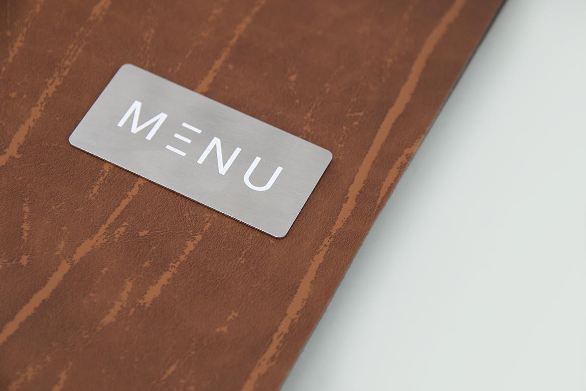 Menypärm i brunt läder med Securit Ruga och ett metallmärke som säger MENU