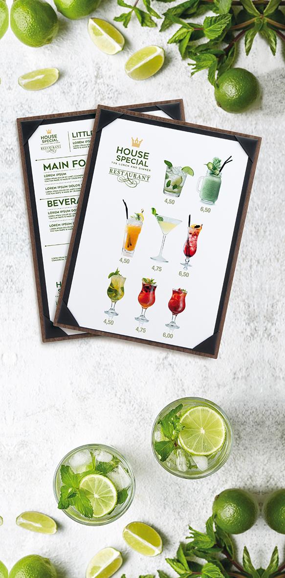 Menykort i träram med drinkmeny, omgiven av lime, mynta och limeklyftor på en ljus yta