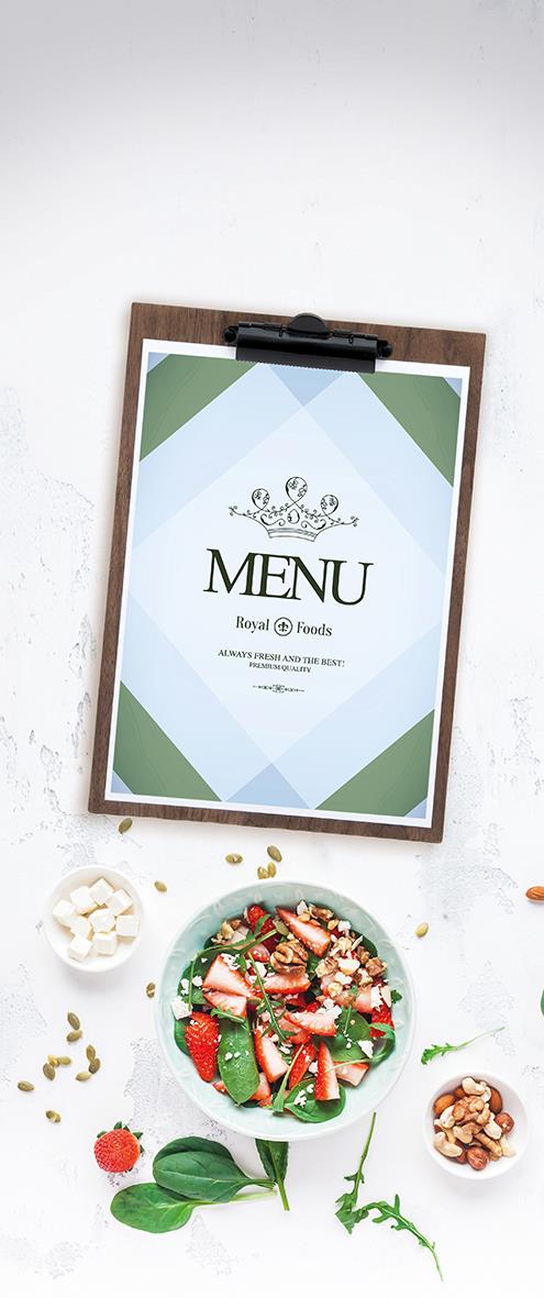 Menynhållare i trä med klämma för A4-menyblad, placerad på vit vägg med sallad och nötter nedanför