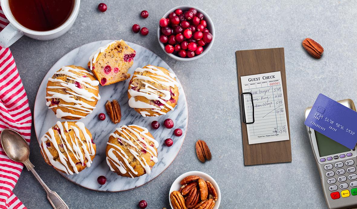 Sju bakverk med glasyr på en vit tallrik, ett kvitto, ett kreditkort och ett kassaregister på en grå bakgrund