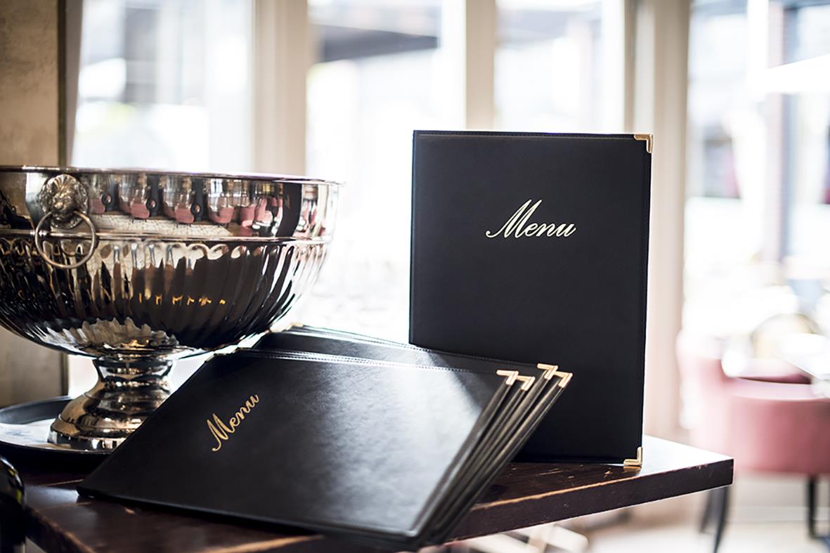 Svart menypärm Securit Classic i A5 storlek med guldfärgad text på ett bord