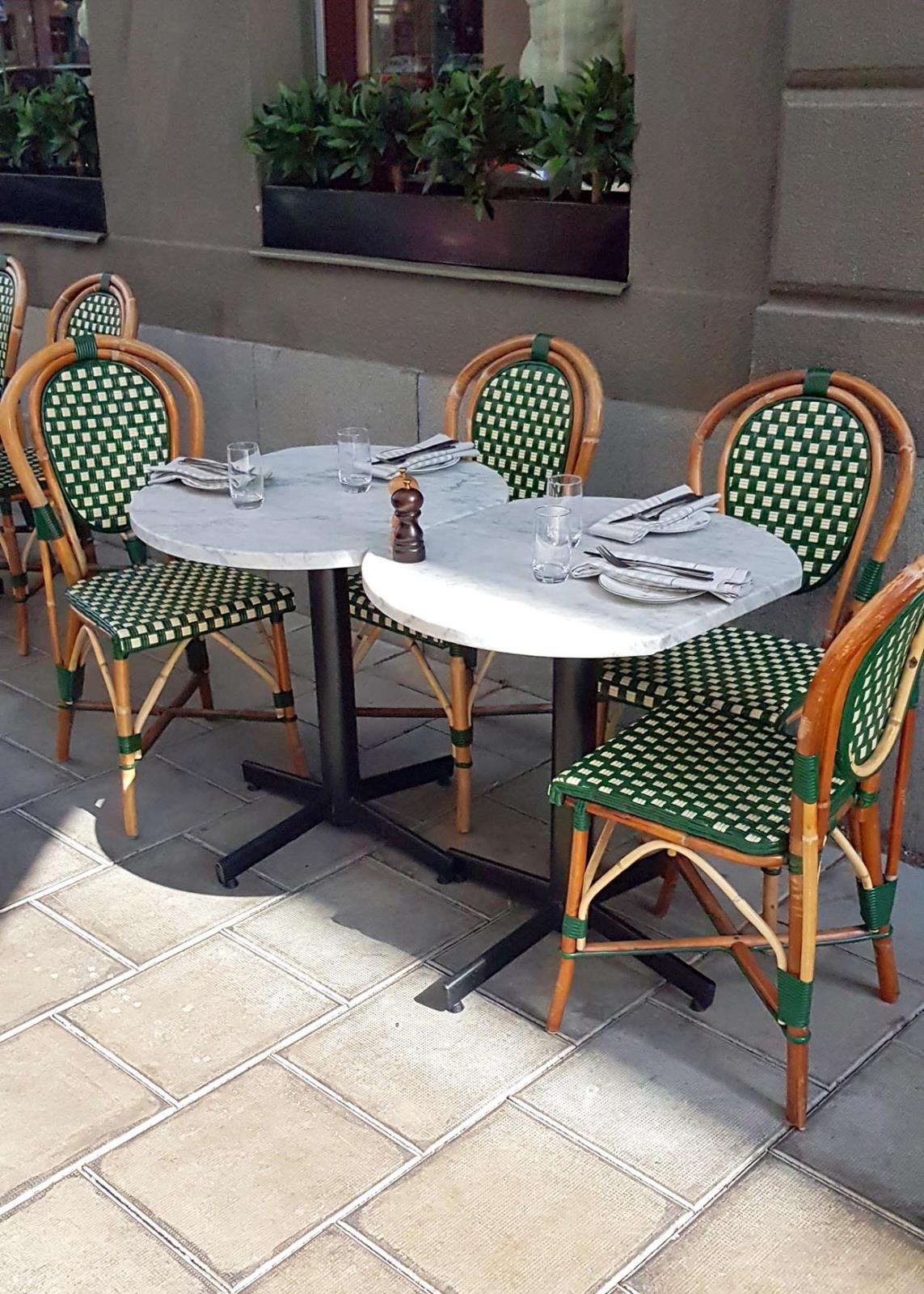 Bordsstativ Stable Table Classic 74 Svart med sex gröna och träfärgade stolar runt ett runt bord på uteservering