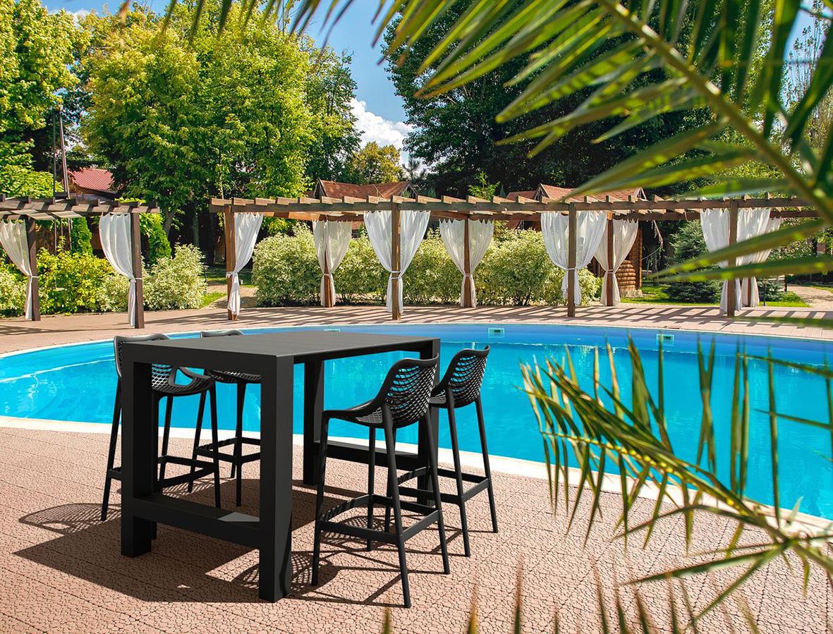 Barstol Air 75cm svart vid pool med träd och parasoller i bakgrunden