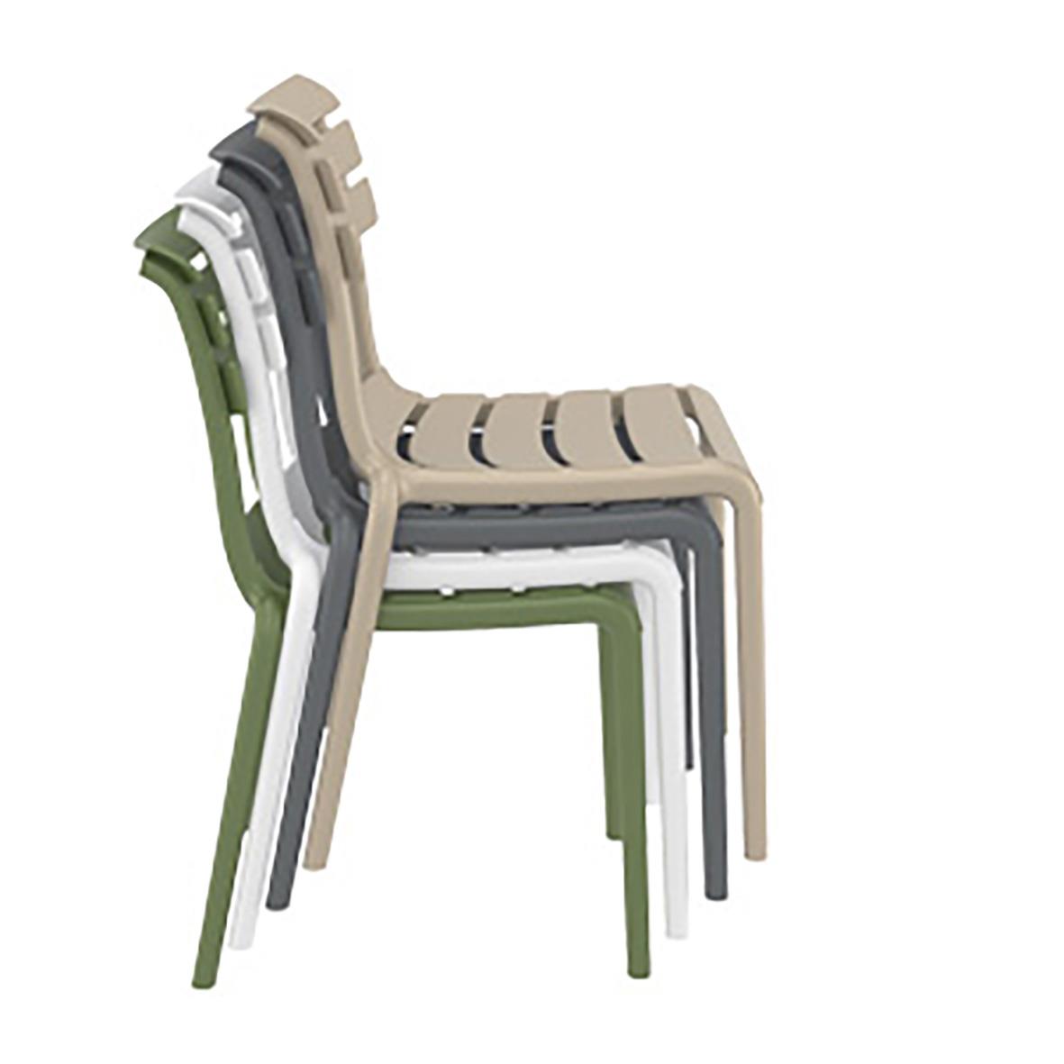 Staplar svarta, vita, beige och gröna stolar staplade på varandra