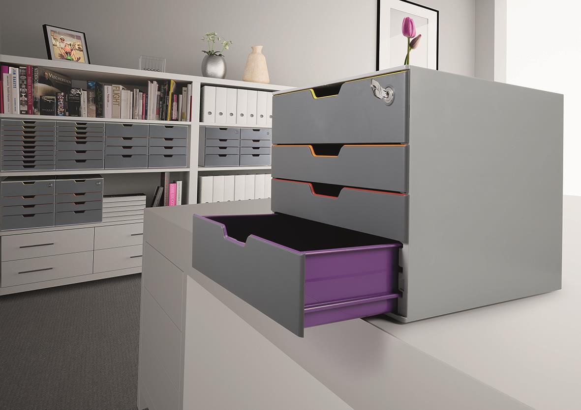 Grå blankettbox med fyra lådor, en av dem är öppen och visar lila insats, placerad på ett skrivbord i ett kontorslandskap