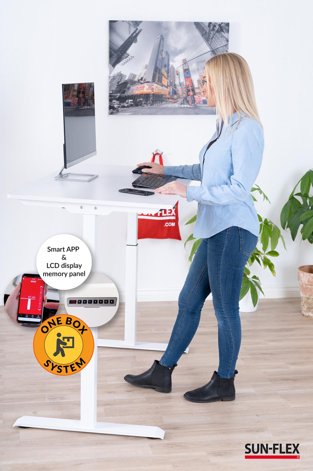 Kvinna använder höj- och sänkbart skrivbord Sun-Flex Easydesk Elite vit 1200x600 mm med dator och skärm i ett kontorsrum