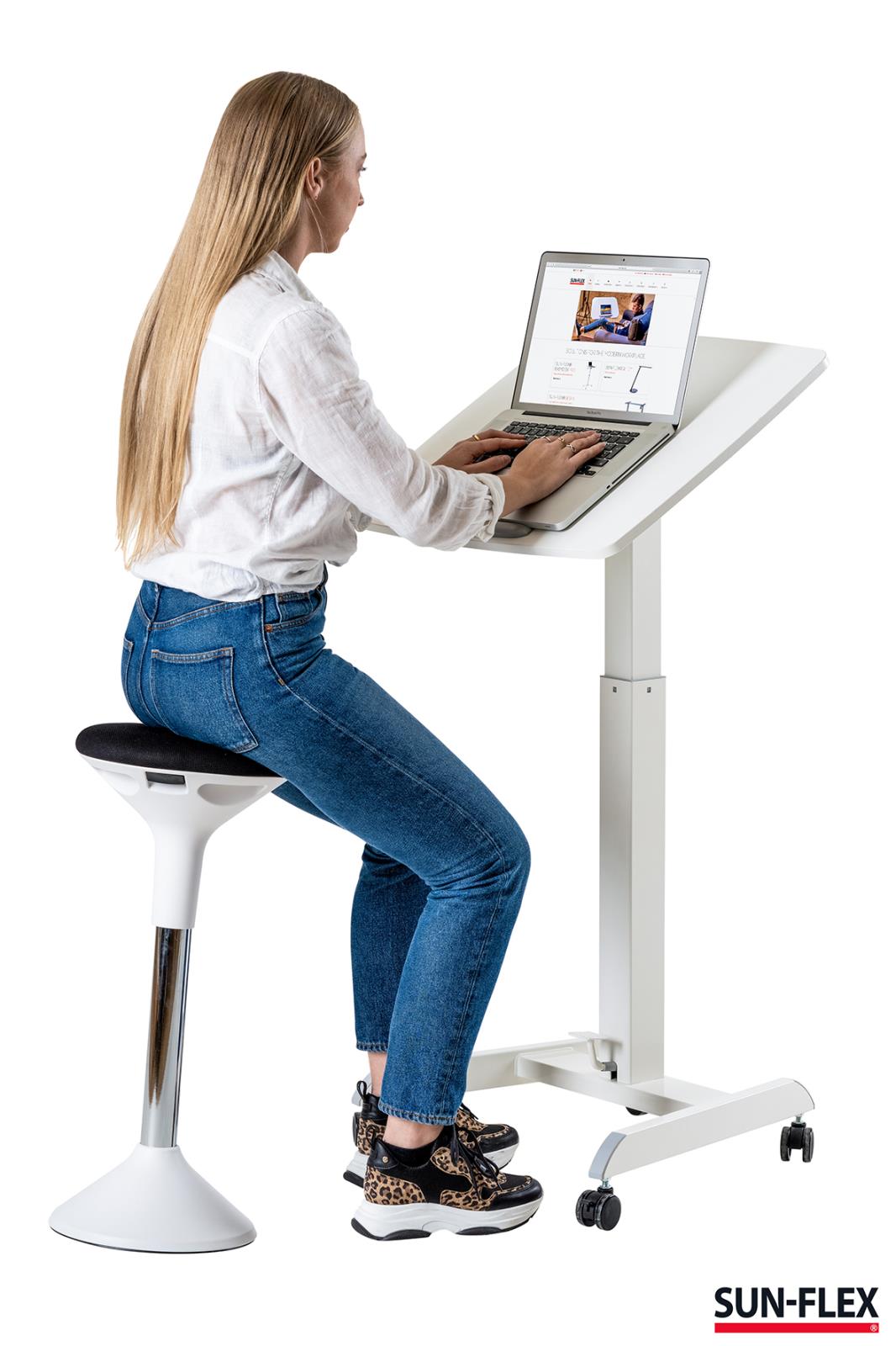 Kvinna sitter vid höj- och sänkbart skrivbord med laptop, vit Sun-Flex Easydesk Pro, 600x520 mm, på hjul