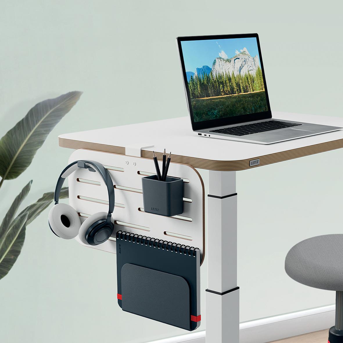 " med pegboard, tillbehör, laptop och hörlurar på skrivbordet"