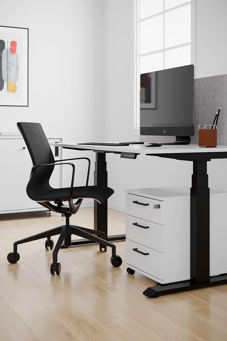 Konferensstol svart vid skrivbord med dator i ett ljust kontorsrum