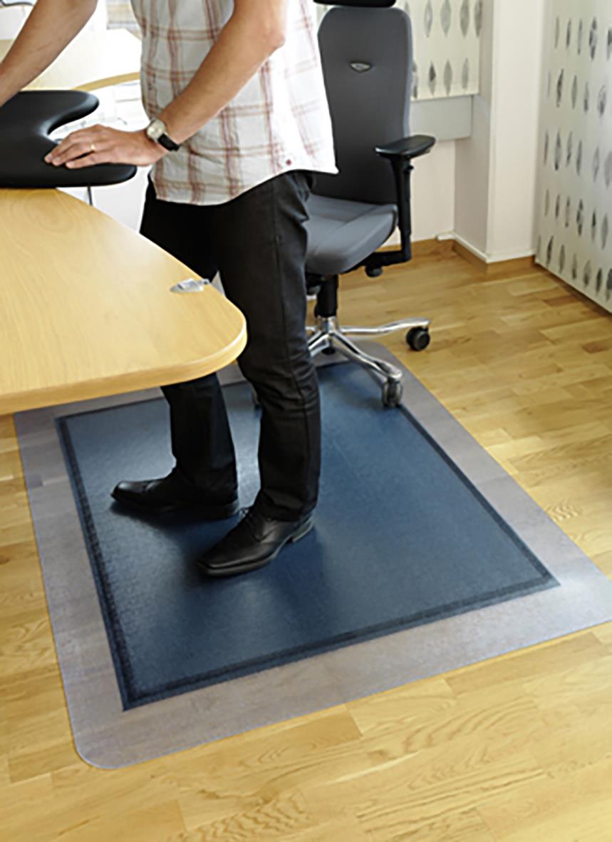 Person står på en blå yogamatta på ett kontorsgolv bredvid ett skrivbord och en kontorsstol