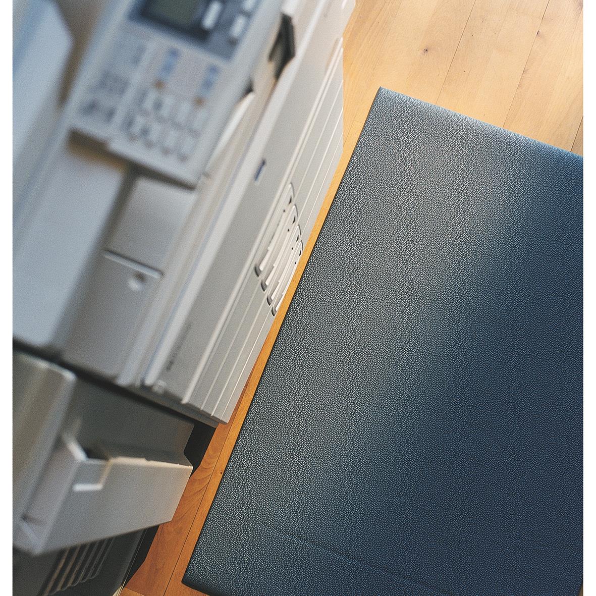 Grå arbetsplatsmatta Matting Yoga Super Plus 61x91cm på golvet bredvid ett skåp