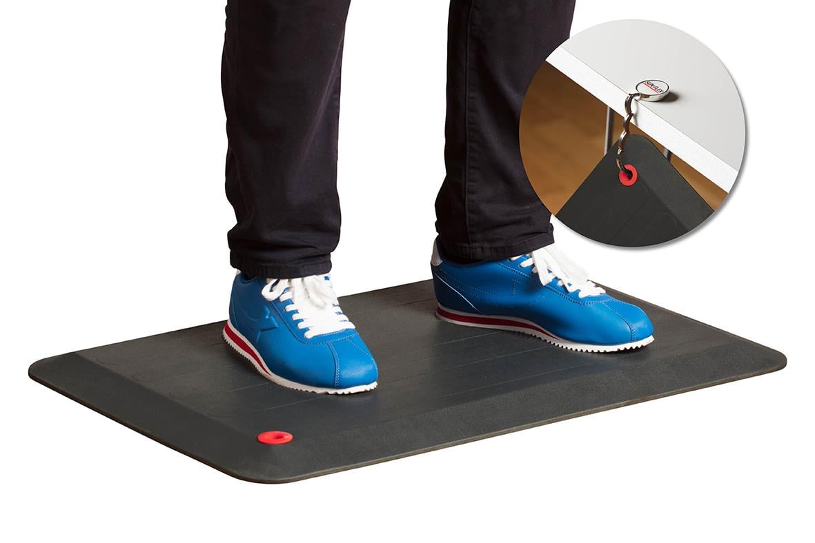 Person står på mörkgrå ståmatta Sun-Flex StandMat med blå sneakers